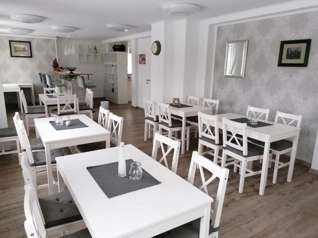WaldheimPension Unikum Waldheim的用餐室配有白色的桌子和白色的椅子