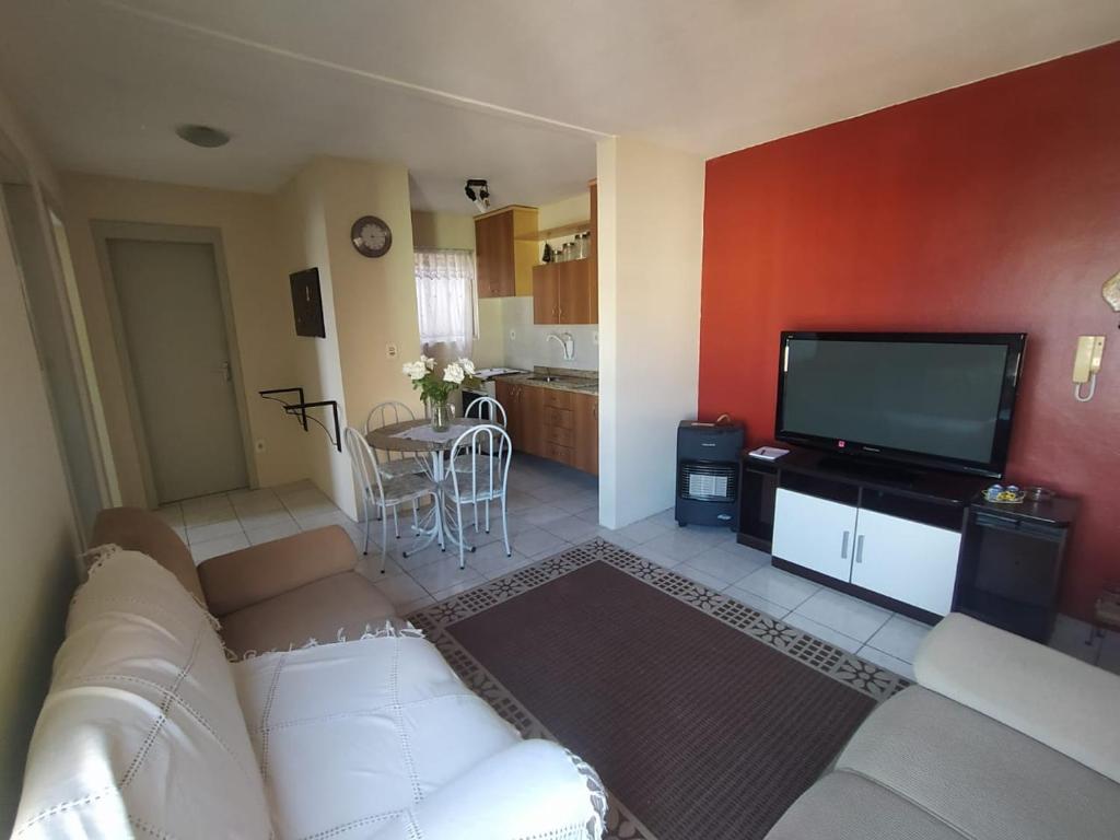 佩洛塔斯Apto 2 quartos, cond fechado, com vaga, quarto andar的客厅配有白色沙发和平面电视。