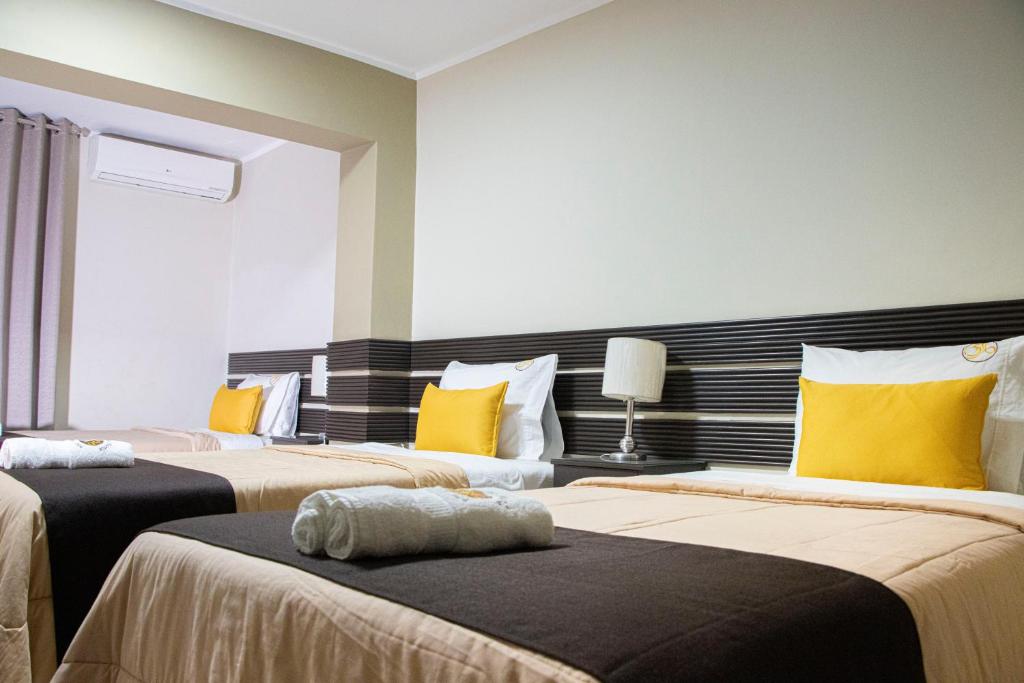 塔拉波托Hotel San Martin的一间卧室配有两张带黄色枕头的床
