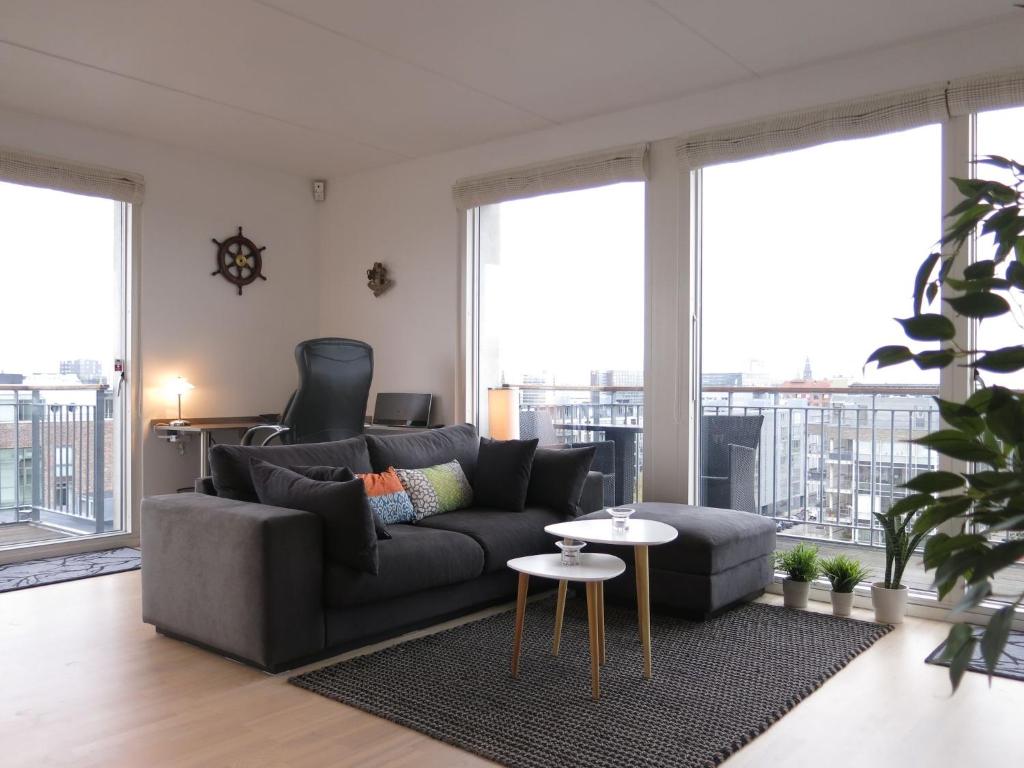 哥本哈根ApartmentInCopenhagen Apartment 427的客厅配有沙发和桌子