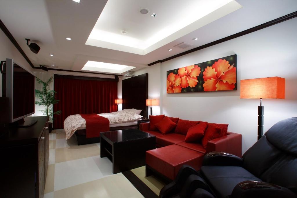 周南市Hotel Water Gate Tokuyama adult only的客厅配有红色的沙发和床。