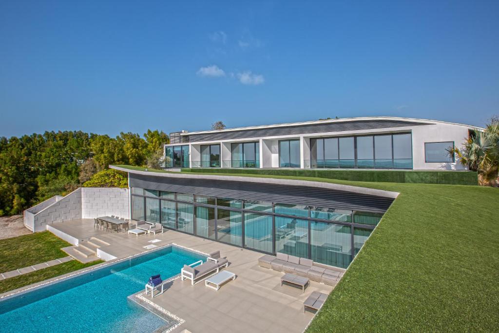 阿布扎比Paradise Nurai Villa - 6 Bedrooms的享有带游泳池的房屋的空中景致