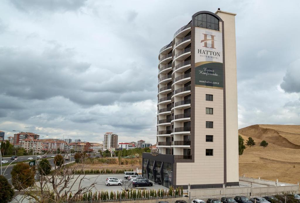 安卡拉Hatton Suites Hotel Esenboga的停车场旁的建筑上标有标志