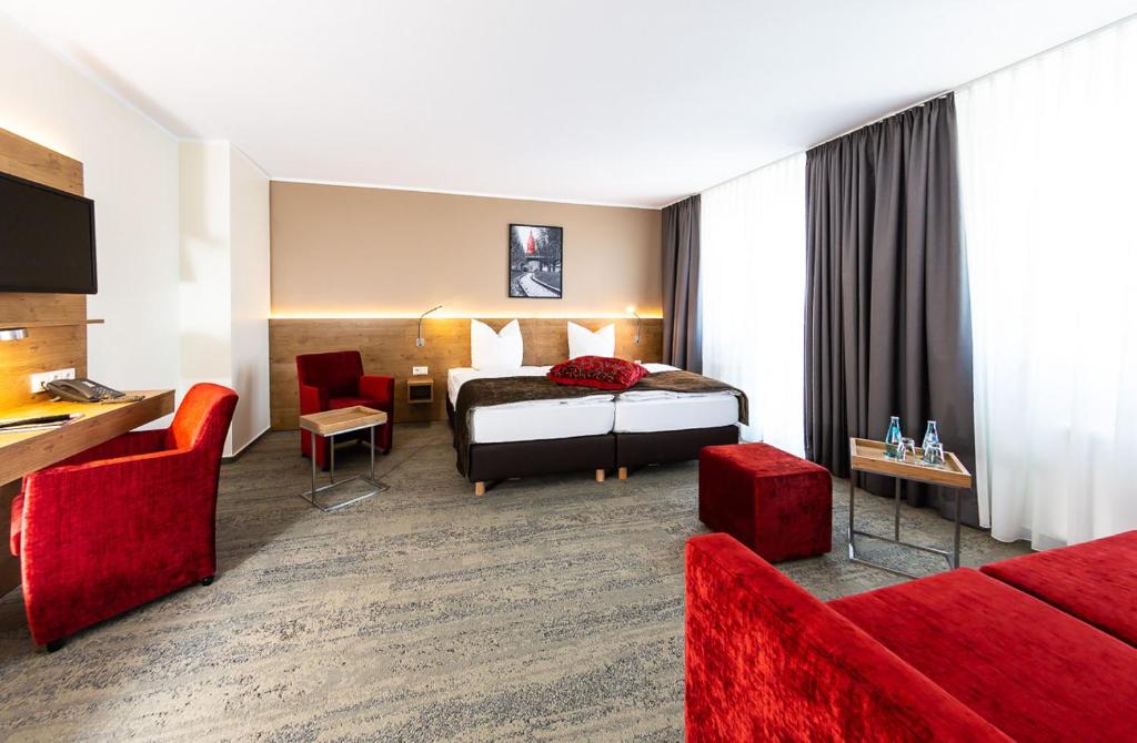 美因河畔法兰克福迈伽酒店的酒店客房配有一张床和红色家具