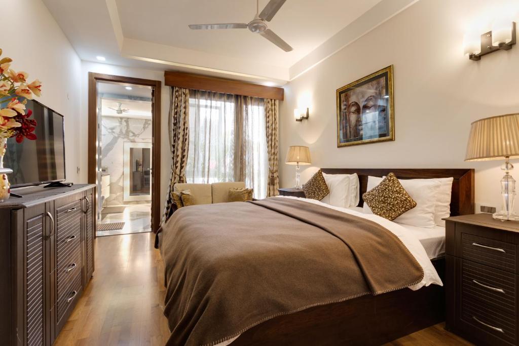 新德里Ishatvam-4 BHK Private Serviced apartment with Terrace, Anand Niketan, South Delhi的一间卧室配有一张大床和电视