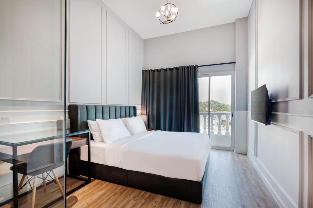 大山脚Wesley Hotel的配有一张床、一张书桌和一扇窗户的酒店客房
