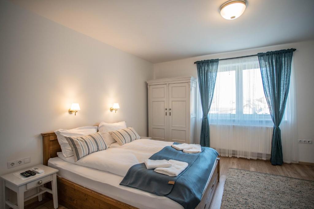 艾格扎洛克Tündérliget Panzió的一间卧室配有一张大床和两条毛巾