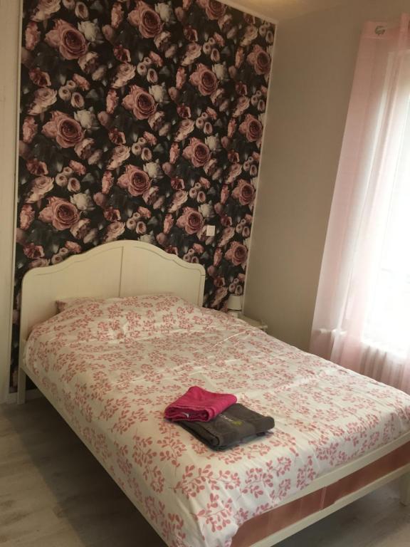 阿布维尔La Vie est Belle的一间卧室配有一张带花卉墙壁的床