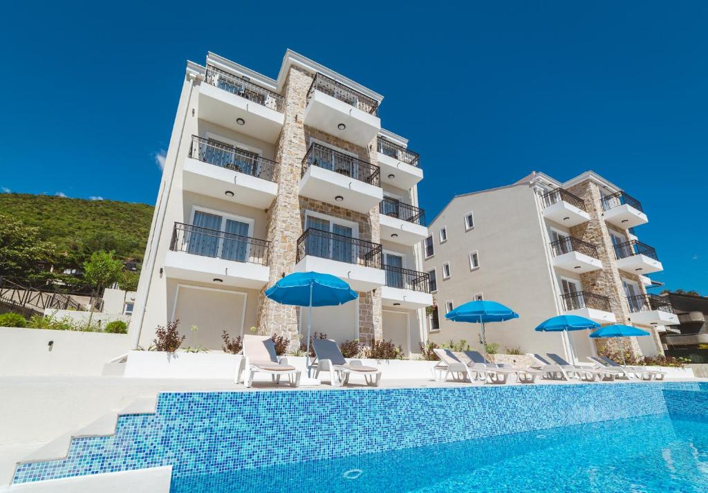 比耶拉Villas Valentina的一个带游泳池和蓝伞的酒店