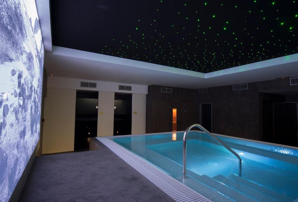圣何塞Hotel La Posada De Paco - Spa & Adults Friendly的一座拥有星空天花板的建筑中的游泳池