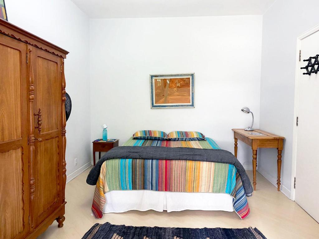 圣保罗Suíte Exclusiva Charmosa e Localização Premium no coração de SP Paulista x Augusta的一间卧室配有一张带彩色毯子的床