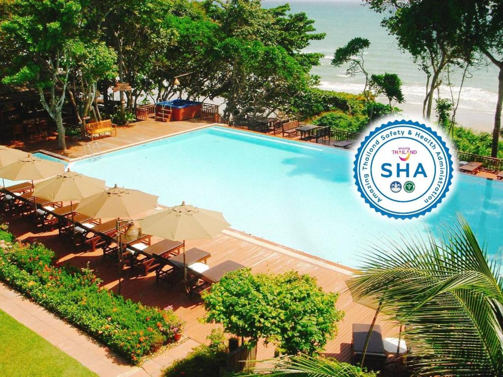 南芭堤雅鸟儿蜜蜂度假酒店的一个带遮阳伞和沙子标志的游泳池