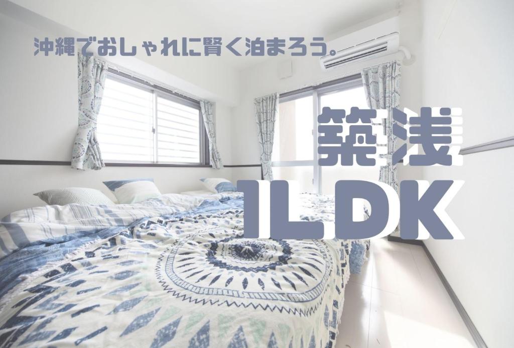 糸满EX Itoman Apartment 701的一间卧室配有一张带蓝色和白色棉被的床