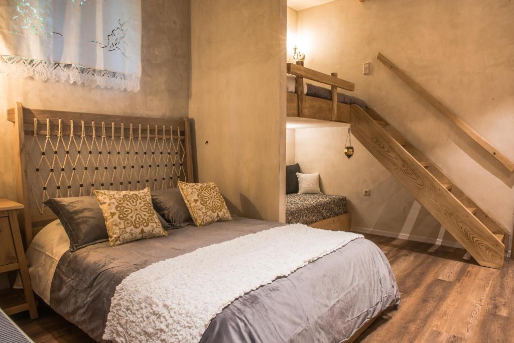Magoúliana«Σκλάβας Χνάρι» Παραδοσιακός Ξενώνας的一间卧室设有一张床和一个楼梯