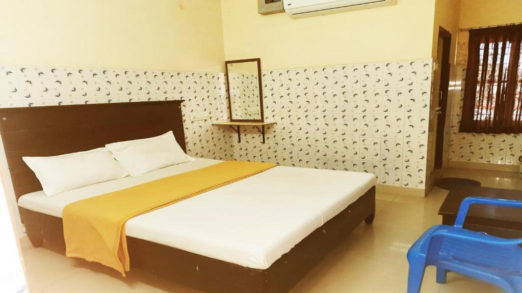 瓦朗加尔Vishnu Residency Warangal的一间卧室配有一张床和一张蓝色椅子