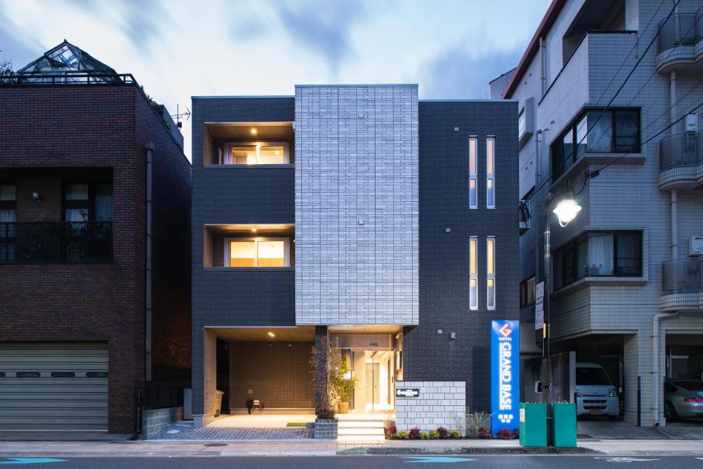 鹿儿岛GRAND BASE Kagoshima Chuo的城市街道上一座黑色房子,有建筑