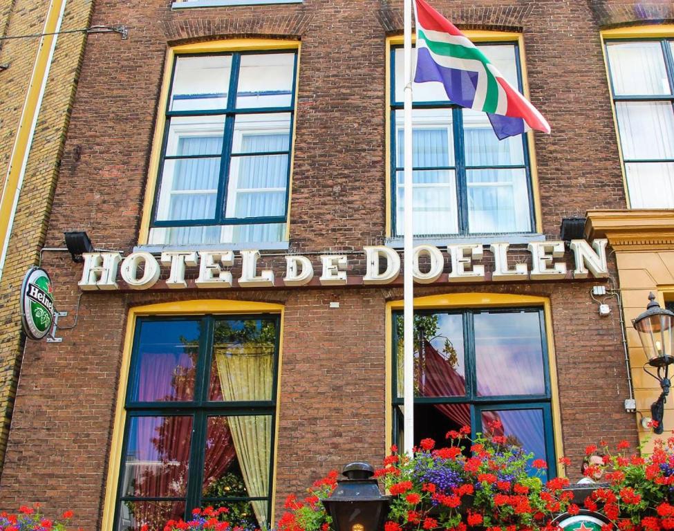 格罗宁根Boutique Hotel De Doelen的大楼内的一个杜布林标志和旗帜