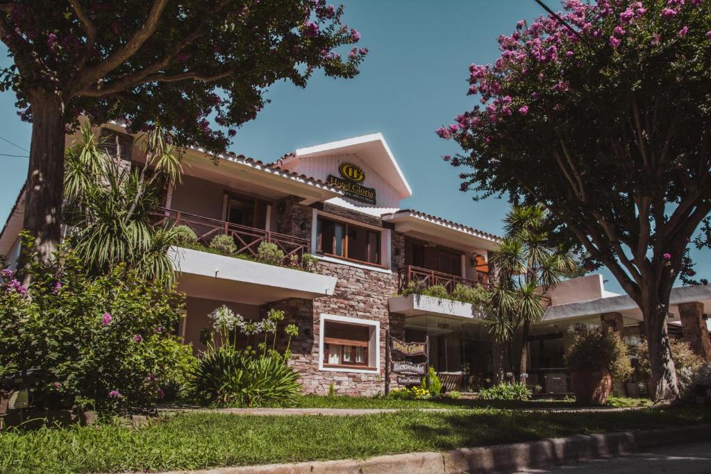 圣罗莎卡拉穆奇塔县凯莱酒店的一座公寓楼,前面有鲜花盛开的树木