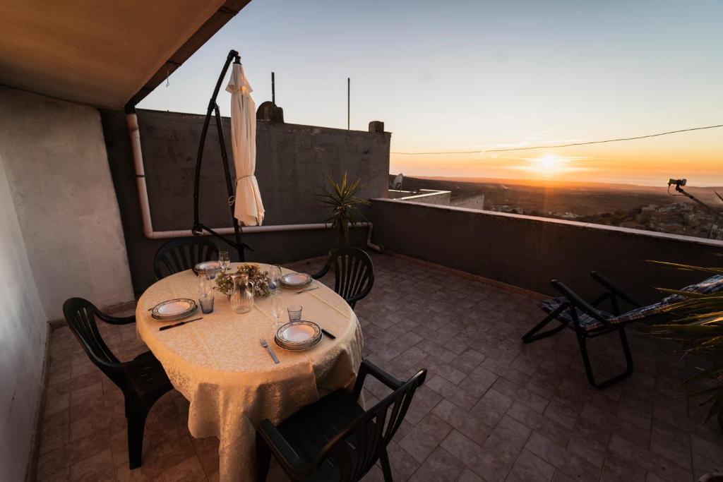 库列里Su 'e Torigheddu - Casa con terrazza panoramica的阳台上的桌椅享有日落美景