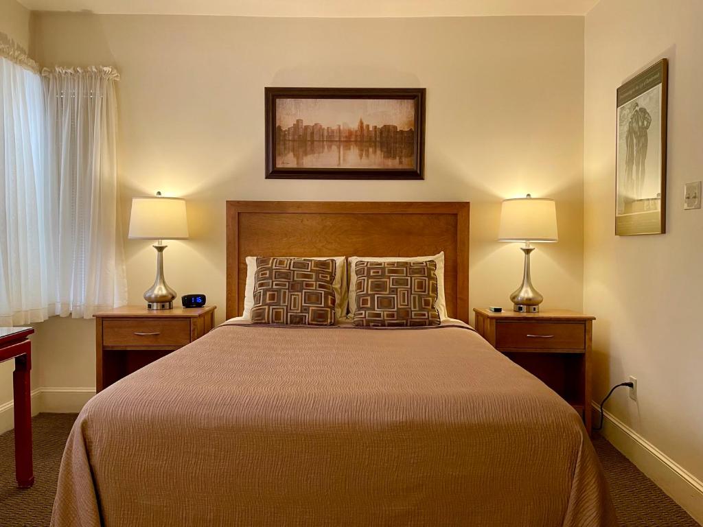 波士顿绿洲宾馆的一间卧室配有一张大床和两盏灯