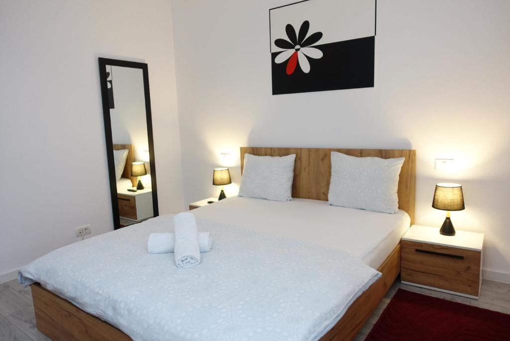 蒂米什瓦拉Balcescu Apartment Self Check-in的一间卧室配有一张带白色床单和镜子的床