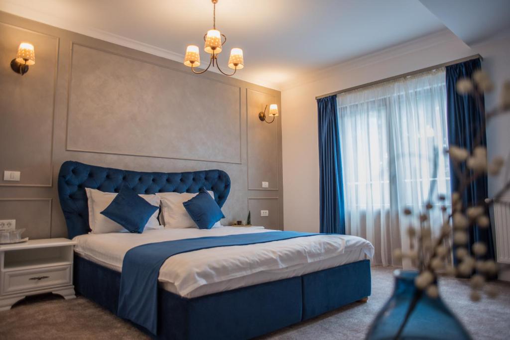 锡纳亚Boga Rooms的一间卧室设有蓝色的床和窗户。