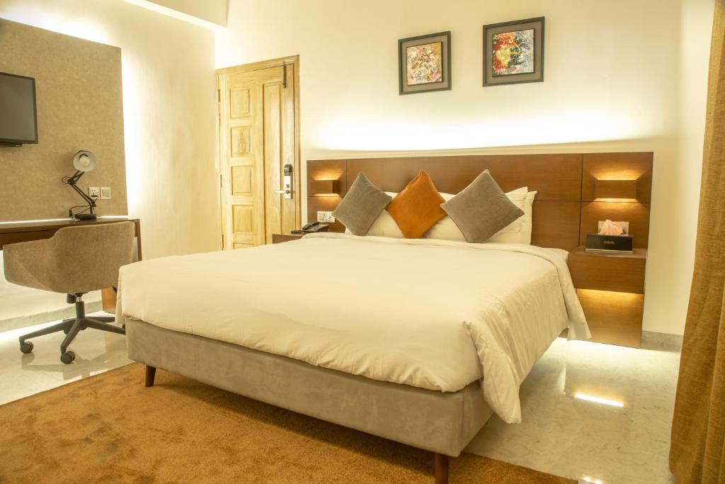 吉大港Jatra Flagship Chattogram City Centre的卧室配有一张白色大床和一张书桌