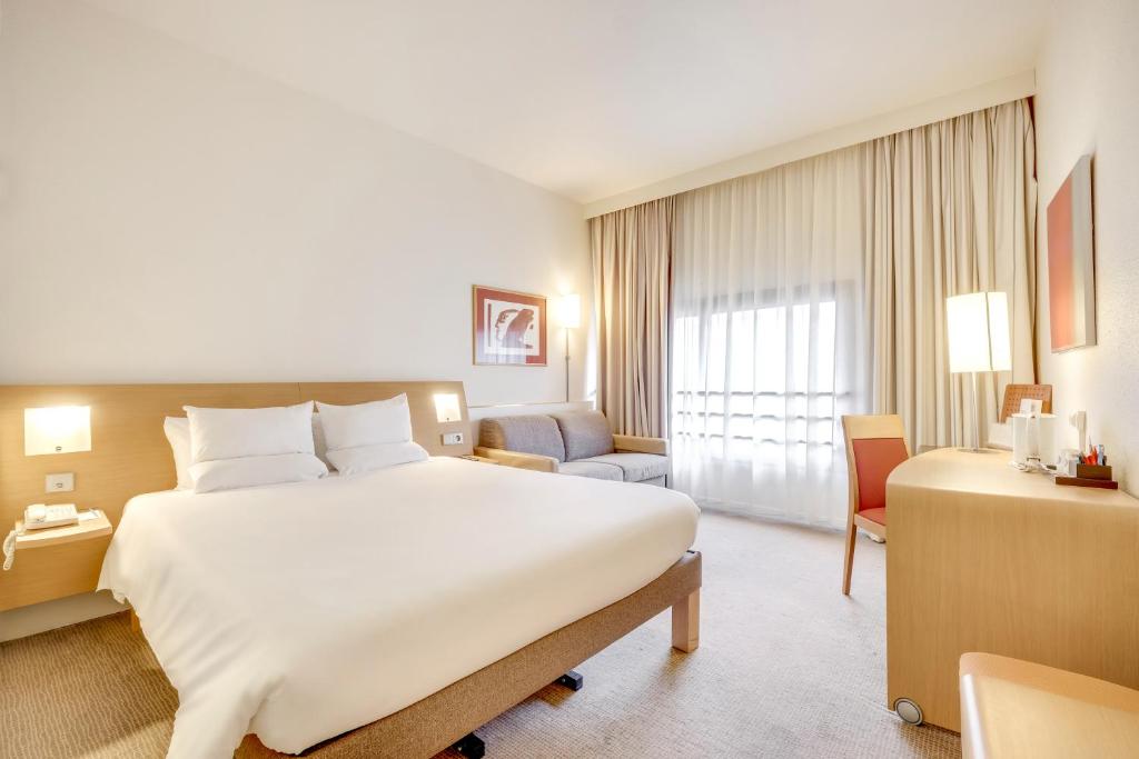 贝尔福贝尔福中心阿特丽亚诺富特酒店的酒店客房带一张大床和一把椅子