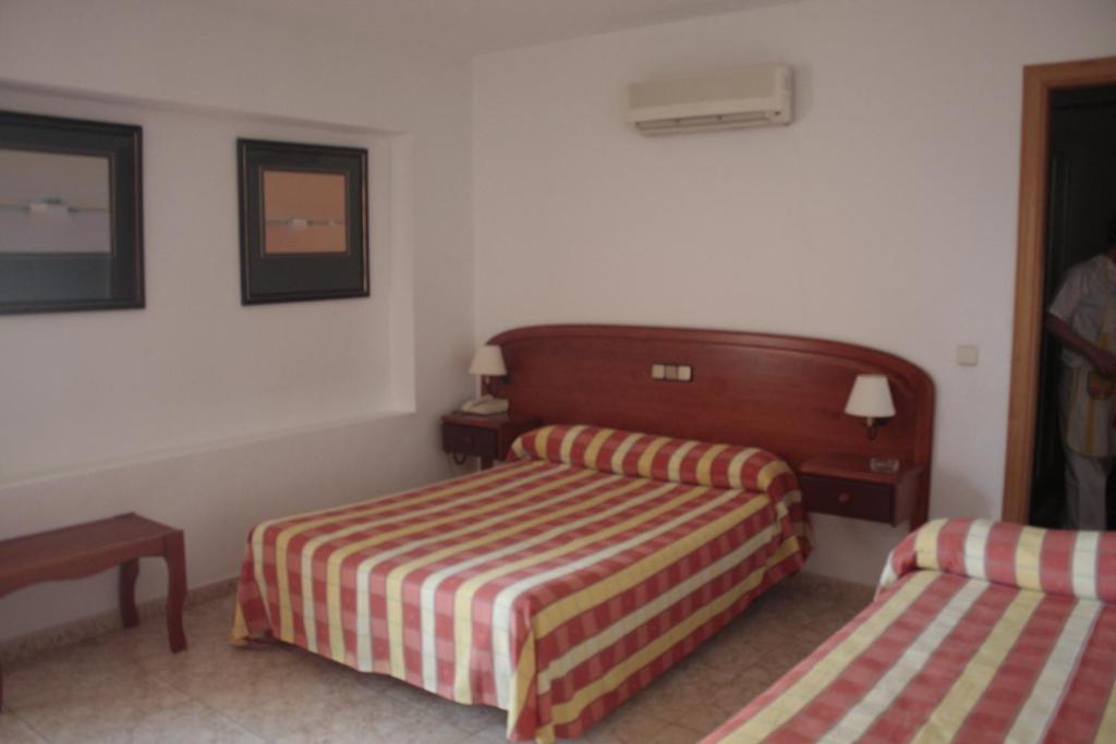 索托德尔雷亚尔阿萨德索托大旅馆 的酒店客房带两张床、一张桌子和一张西德西德克斯床