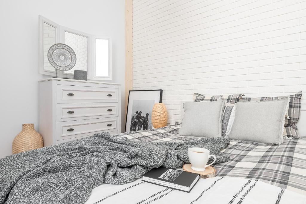 黑杜纳耶茨Apartament Biała Perła的卧室配有一张带毯子和咖啡的床。