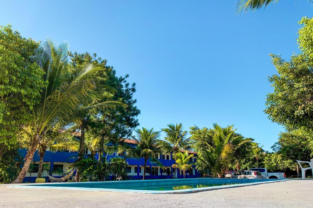 塞古罗港Pousada Migo的棕榈树游泳池度假村