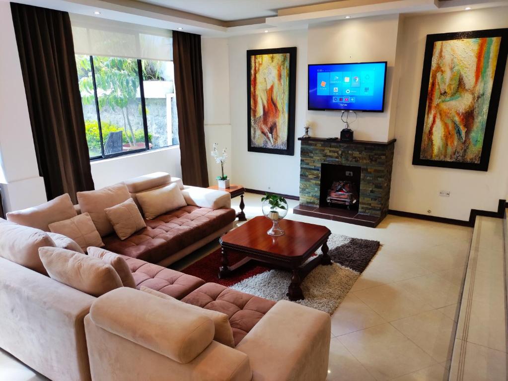 基多Hospedaje en Quito Norte, Apartamento & Suite independientes的带沙发和壁炉的客厅