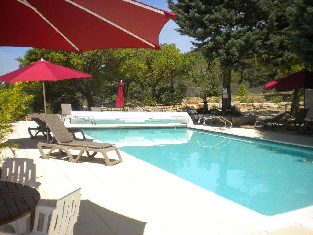 圣马克西姆马斯圣多那酒店的一个带两把椅子和遮阳伞的游泳池