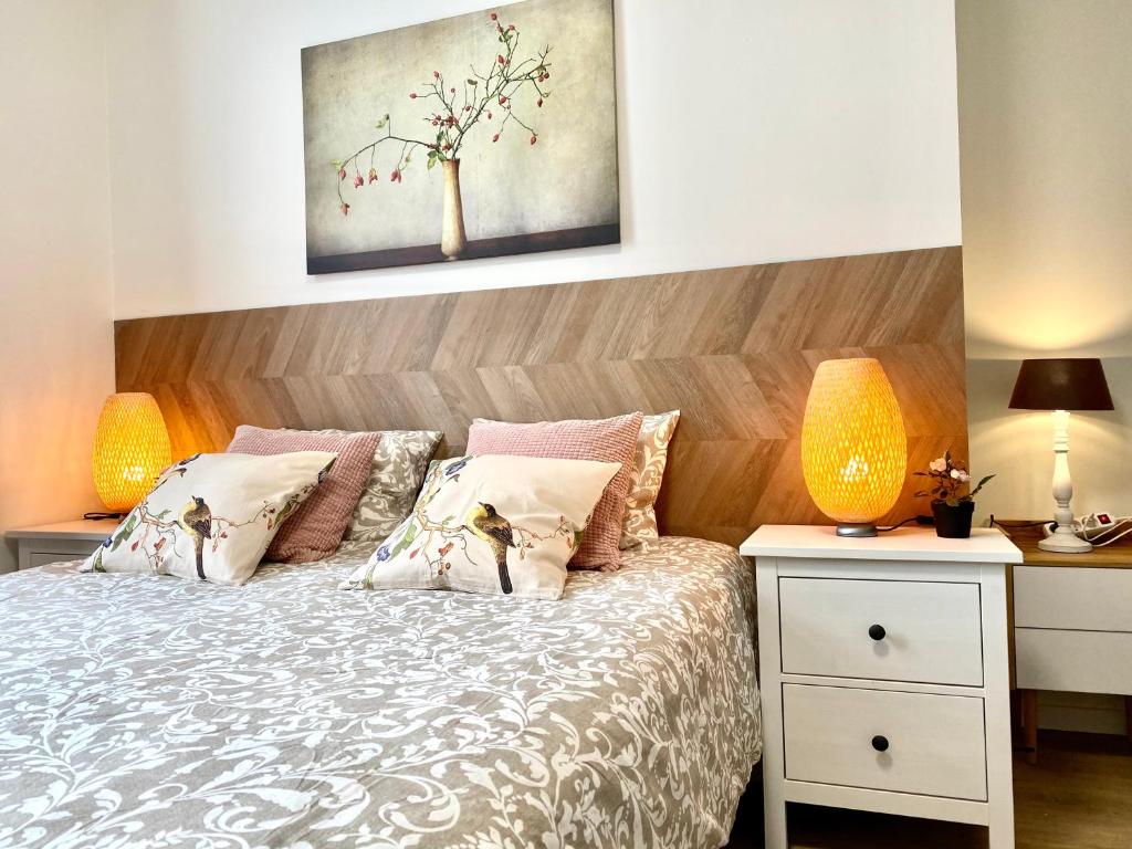安特卫普Сarnot Apartments ZOO Area的一间卧室配有一张带木制床头板的床