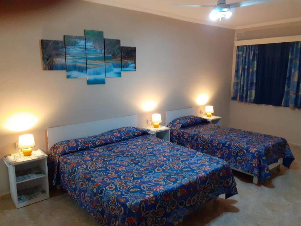 姆西达Black Gold Private Room的酒店客房设有两张床和两盏灯。
