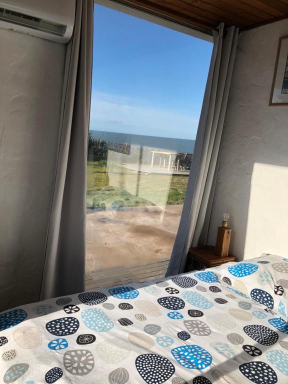 LʼÉpineLa Mer & La Dune的一间卧室设有一张床和一个大窗户