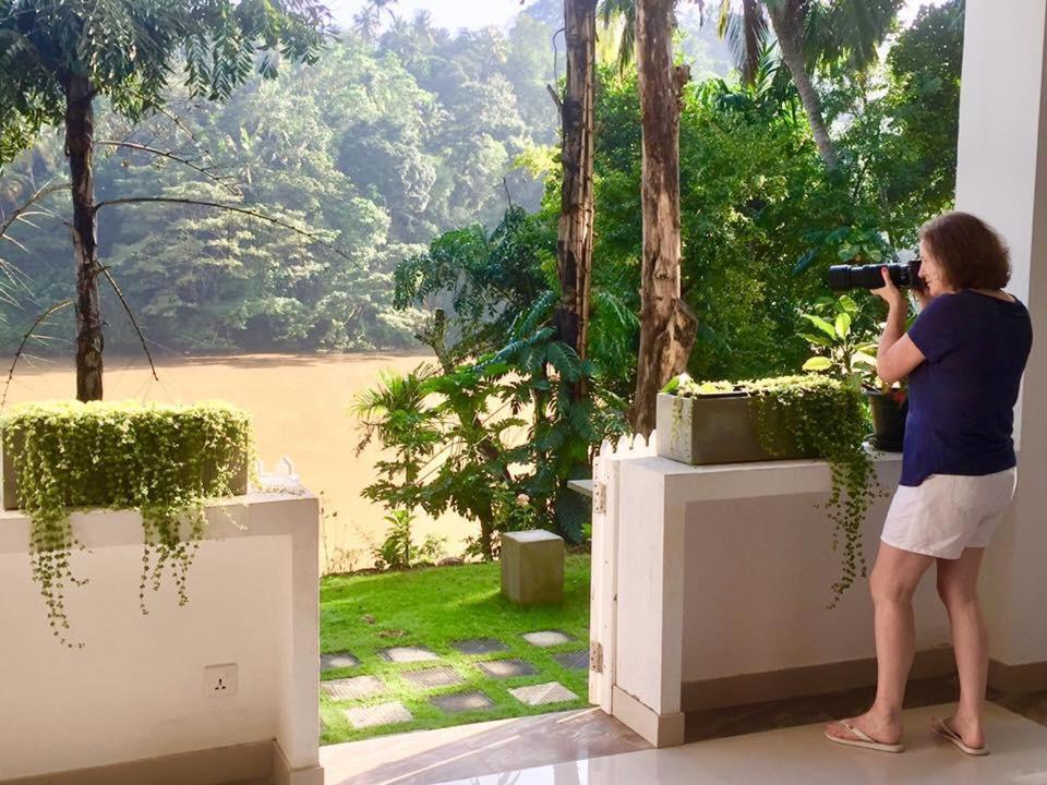 康提康提河畔自然度假村的一位女士用相机拍一幅窗户的照片