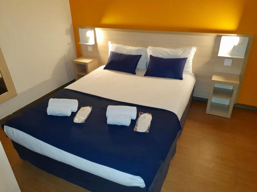 达马利百合Budget Hotel Melun Sud - Dammarie Les Lys的一间卧室配有一张大床,上面有两张拖鞋