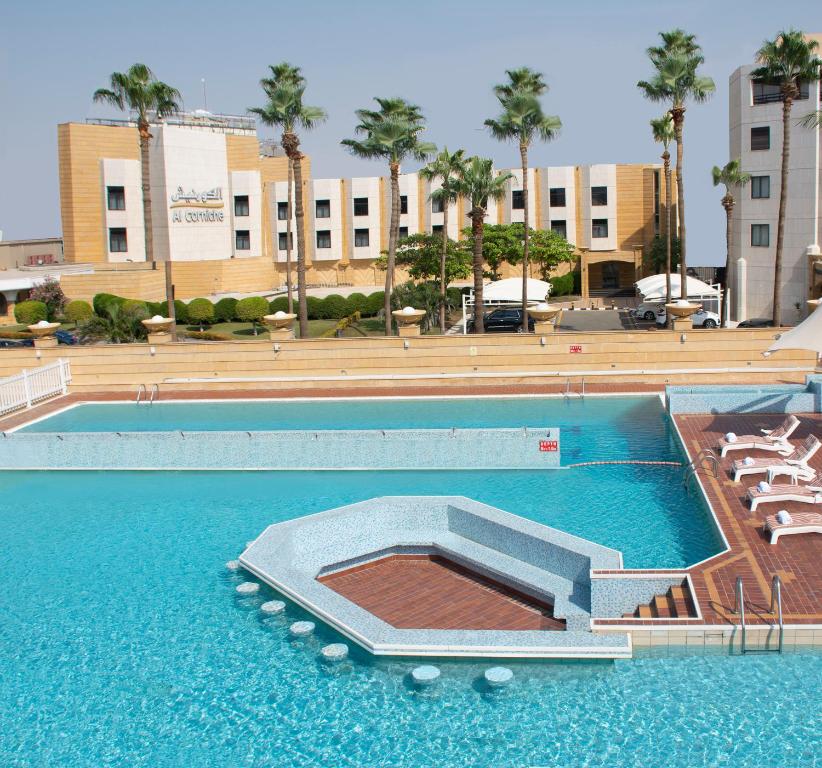 吉达Al Corniche的一座带椅子的空游泳池以及一座建筑