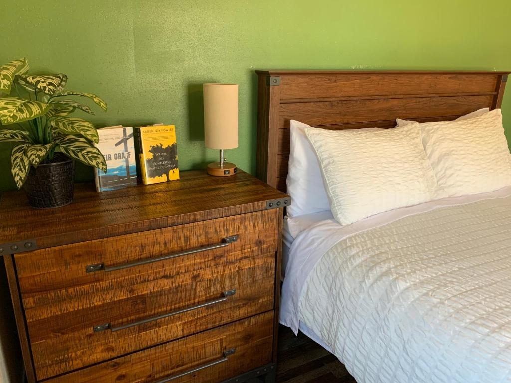 MarysvilleTrailhead Suites的一间卧室配有一张床和一个带灯的木制梳妆台