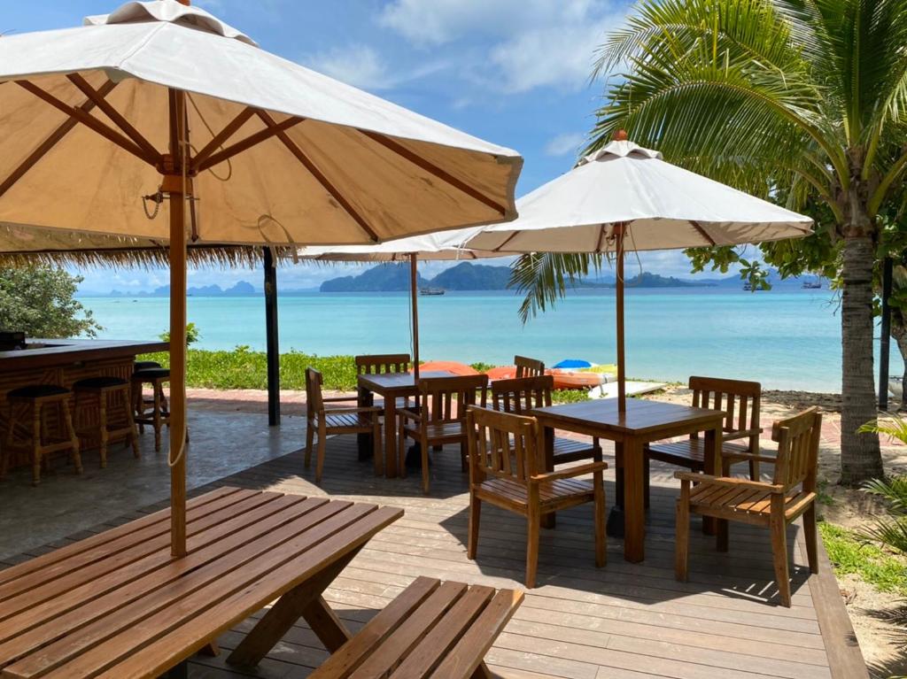 克雷登岛Mali Kradan的海滩上设有桌子和遮阳伞的餐厅