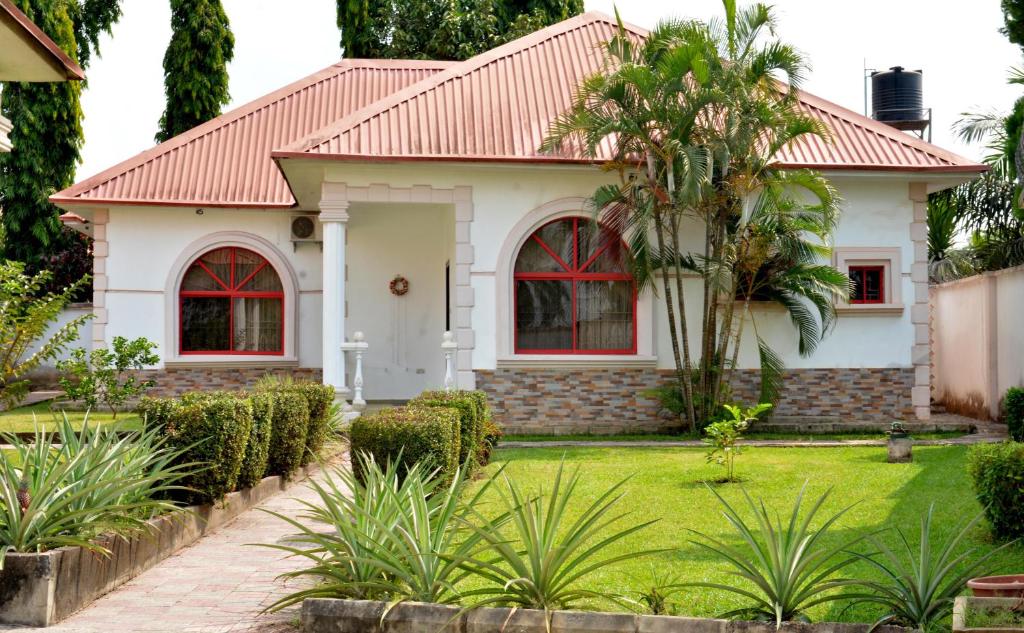 伊巴丹2 Bedroom Bungalow in Alalubosa GRA的一座红色屋顶和绿色庭院的房子