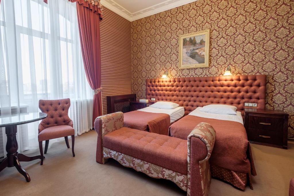 莫斯科北京酒店的酒店客房,配有两张床和椅子