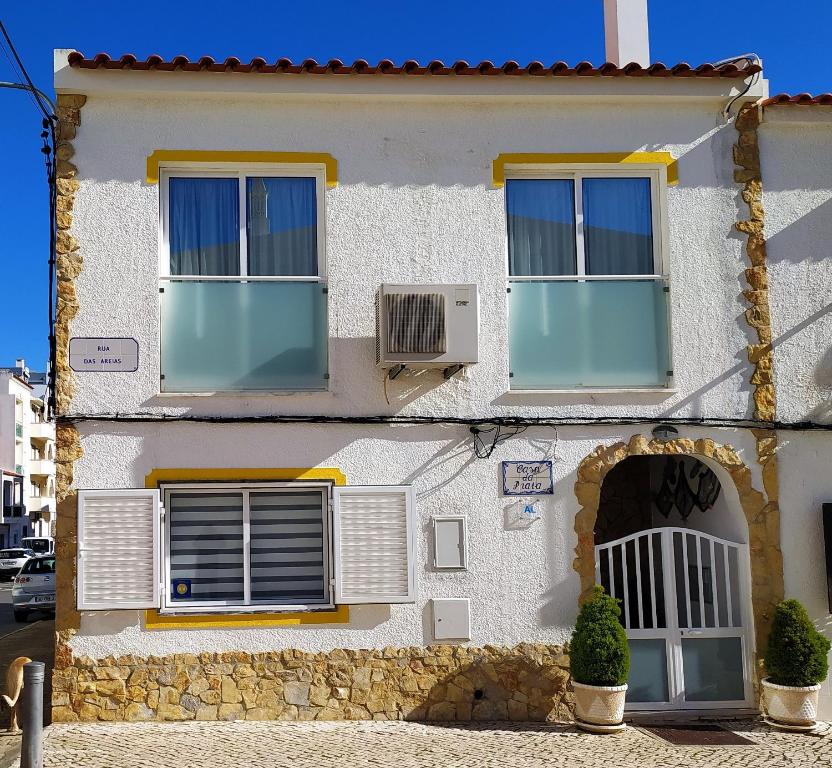 蒙蒂戈杜Casa Da Praia "AL"的白色的房子,设有2扇窗户和风扇