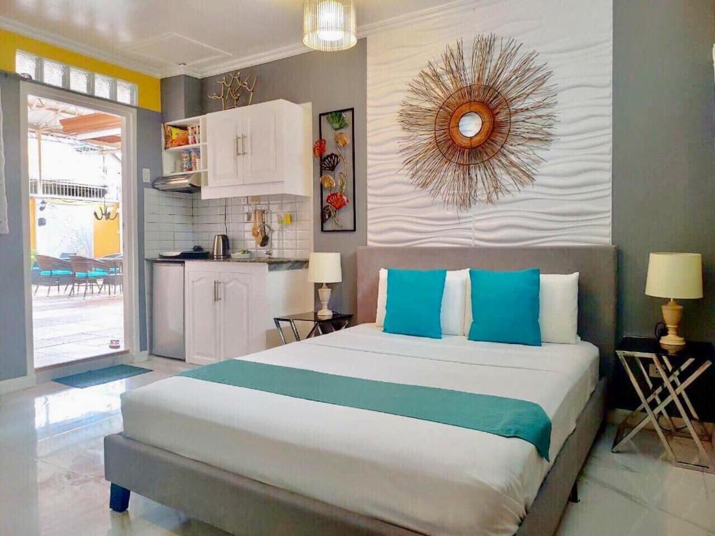 麦克坦Little Norway Guesthouse - Mactan Cebu International Airport的一间卧室配有一张带蓝色枕头的大床