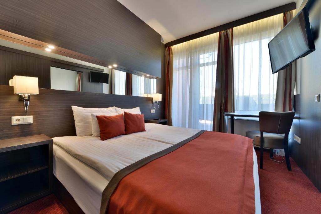 布达佩斯城市之家酒店的酒店客房设有一张大床和一张书桌。