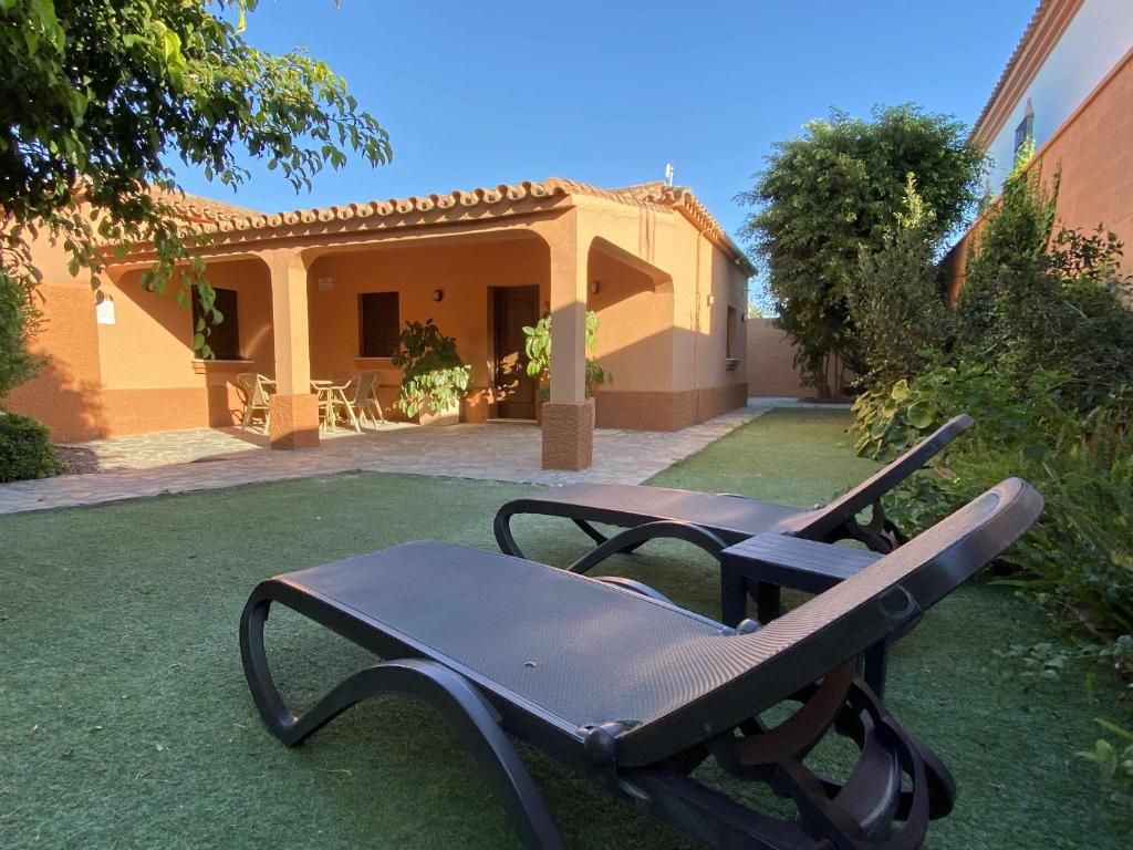 加的斯Casa con jardín privado para hasta 7 personas y piscina compartida的房屋前院里的椅子