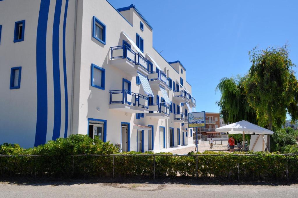 坎波马里诺Campitur的白色的大建筑,设有蓝色的阳台和雨伞