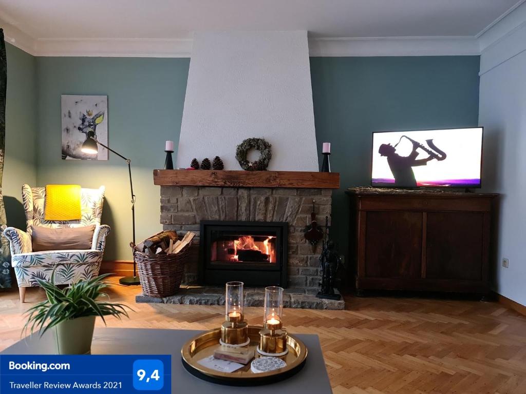 布永Au Pied Du Château的客厅设有壁炉和电视。