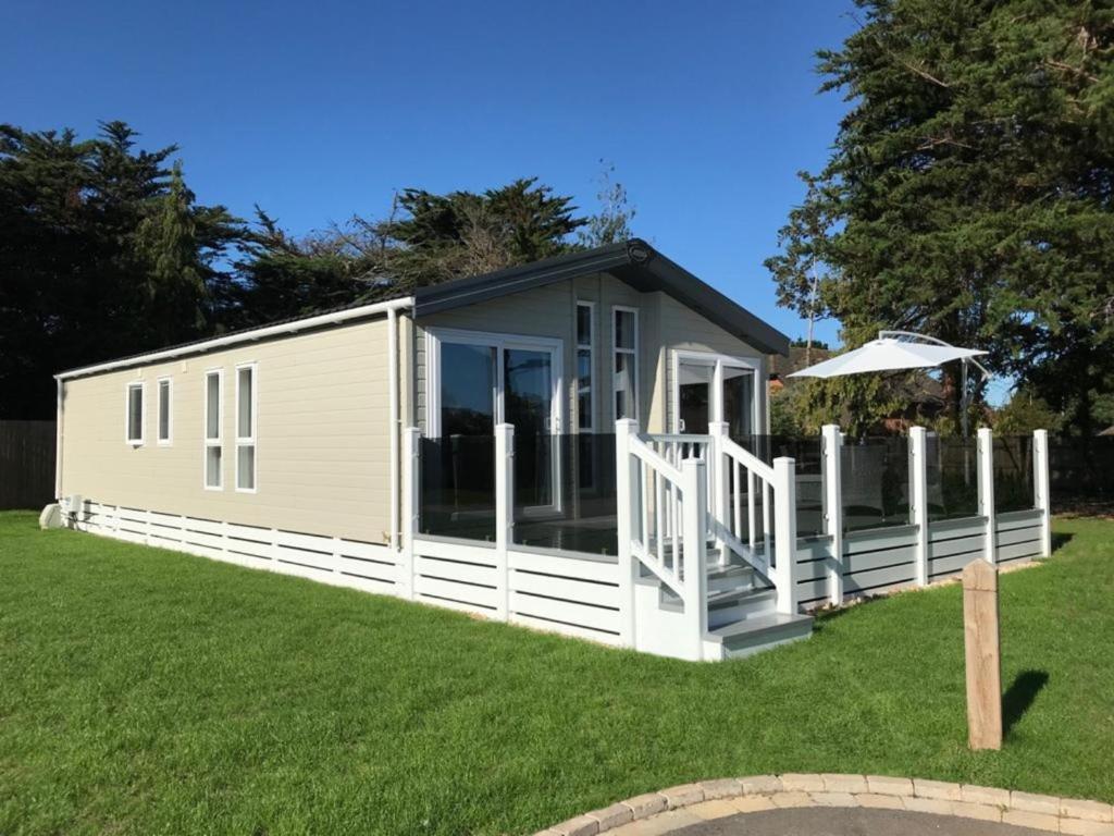 基督城6 berth luxury lodge in Christchurch Dorset的一个小房子,设有门廊和甲板